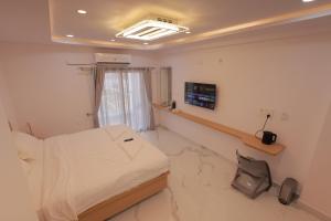 a hospital room with a bed and a television at Hotel Vibrama in Tirupati +35 photos