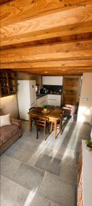 a living room with a wooden table and a kitchen at Enfin Clavon - appartamento in baita in Verrayes