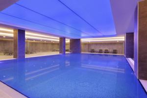 ein großes Schwimmbecken in einem Gebäude mit blauer Beleuchtung in der Unterkunft La Quinta by Wyndham Istanbul Gunesli in Istanbul