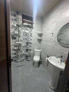 a bathroom with a toilet and a sink at Luso in Batumi +10 photos