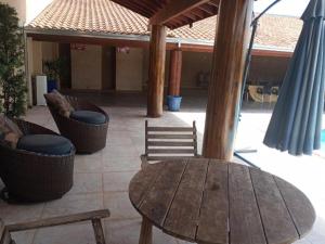 a wooden table and chairs on a patio at Recanto Barretos in Barretos +13 photos