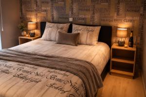 a bedroom with a large bed with words on the wall at Maison Samree met Indoor Wellness in La-Roche-en-Ardenne