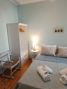 a bedroom with two beds and a chair and a lamp at Lefkada Old Town Kantouni in Lefkada