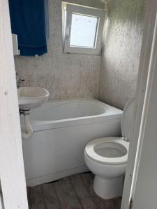 a bathroom with a tub and a toilet and a sink at Britania Hobbit in Predeluţ +10 photos