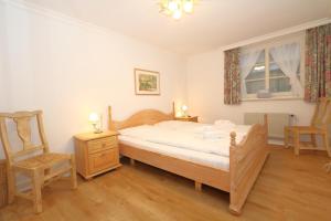 a bedroom with a bed and a chair and a window at Appartement-Morgenroth in Munkmarsch