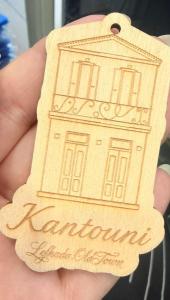 a hand holding a wooden object with a building on it at Lefkada Old Town Kantouni in Lefkada