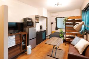 a small living room with a couch and a table at Osaka Petite Tanuki Inn Neyagawa in Neyagawa +48 photos