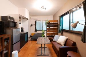 a living room with a couch and a table at Osaka Petite Tanuki Inn Neyagawa in Neyagawa