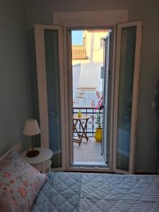 a bedroom with a bed and a view of a balcony at Lefkada Old Town Kantouni in Lefkada +17 photos