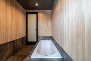 a bath tub in a room with wooden walls at The Terrace MAKINO in Takashima