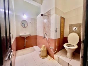 a bathroom with a shower and a toilet and a sink at Manipal Downtown in Manipal