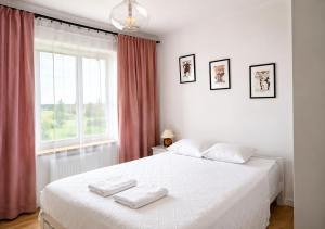 a bedroom with a white bed with two towels on it at Rezydencja Tyrawa in Tyrawa Solna