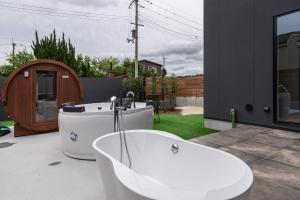 a white bath tub sitting on the patio of a house at The Terrace MAKINO in Takashima