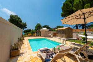 a pool with a table and chairs and an umbrella at Tsanta house in Agios Gordios