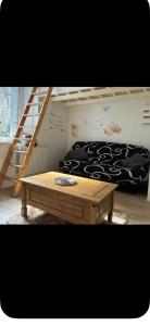 a room with a bunk bed and a wooden table at Le passage in Saint-Brieuc