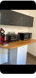 a microwave and a toaster oven on a table at Le passage in Saint-Brieuc