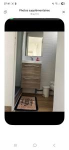a picture of a bathroom with a sink and a mirror at Le passage in Saint-Brieuc