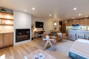 a living room with a fireplace and a kitchen at Switchback at Edelweiss in Whitefish +26 photos