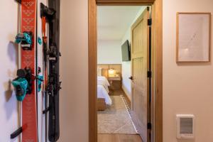 a room with a door leading to a bedroom with a snowboard at Switchback at Edelweiss in Whitefish