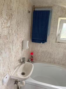 a bathroom with a white sink and a blue towel at Britania Hobbit in Predeluţ