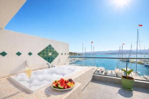 a bath tub with a bowl of fruit on a balcony at Harbour Suites Fethiye in Fethiye