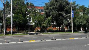 an empty street with yellow barriers on the side of the road at Eden Apartament in Bucharest