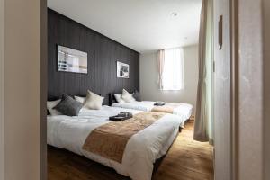 two beds in a hotel room with wooden floors at The Terrace MAKINO in Takashima +30 photos