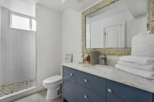 a bathroom with a sink and a toilet and a mirror at Beachfront Condo on A LowKey Beach in Sunset Beach +73 photos