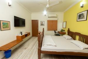 a bedroom with a bed and a tv on the wall at Ishan Apartments 3BHK in Vadodara