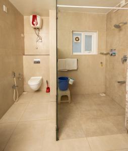 a bathroom with a shower and a toilet at Ishan Apartments 3BHK in Vadodara +28 photos