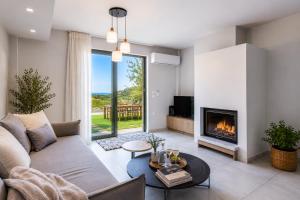 a living room with a couch and a fireplace at Physis Villas Chania in Ayiá