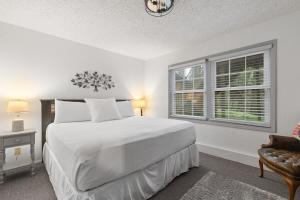 a white bedroom with a large bed and a window at Stones Throw in Hill City