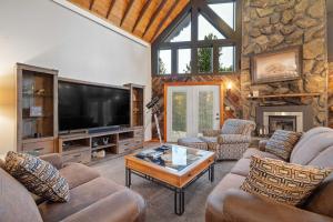a living room with couches and a flat screen tv at Stones Throw in Hill City