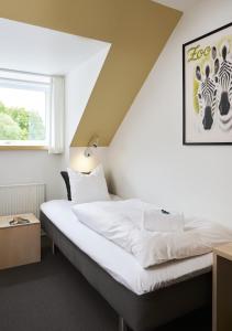 a bedroom with a white bed in a room at Severin Kursuscenter og Konferencehotel in Middelfart