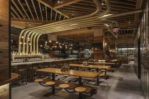 a restaurant with wooden tables and a bar at Hyatt Regency Tysons Corner Center in Tysons Corner
