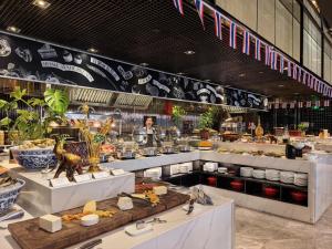 a restaurant with a buffet of food on display at Kempinski Hotel Beijing Yansha Center in Beijing