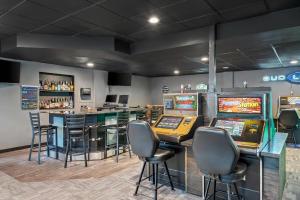 a gaming room with several pinball machines and a bar at Big Horn Resort, an Ascend Collection Hotel in Billings