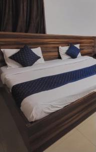 a bed with a wooden head board with pillows on it at Mata Guest House in Katra