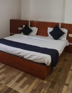 a bedroom with a large bed with white sheets and pillows at Mata Guest House in Katra
