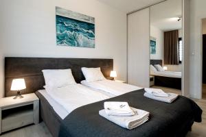 a bedroom with a large bed with towels on it at AWO Apartamenty in Łeba