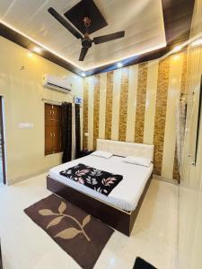 a bedroom with a bed and a ceiling fan at Kanak Bihari Enclave in Ayodhya