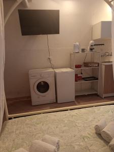 a laundry room with a washing machine and a tv at Curtigghiu Room in Avola