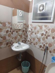 a bathroom with a sink and a toilet at Harichandhanam stay in Guruvāyūr