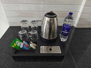 a coffee maker and a bottle of water on a counter at Harichandhanam stay in Guruvāyūr