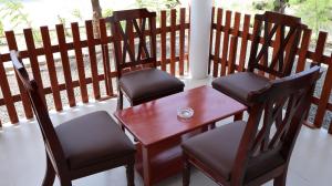 a wooden table and two chairs on a porch at Adam's Palm Resort in Talaimannar
