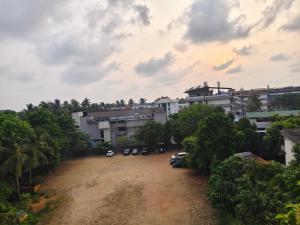 a parking lot with cars parked in front of buildings at Harichandhanam stay in Guruvāyūr +4 photos
