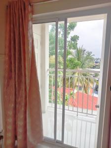 a window with a view of a balcony at Harichandhanam stay in Guruvāyūr