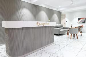 a reception desk in a lobby with a table and chairs at Hotel Sun Lorem, Ahmedabad in Ahmedabad