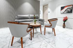 a living room with a couch and a table and chairs at Hotel Sun Lorem, Ahmedabad in Ahmedabad
