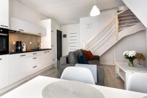 a living room with a couch and a staircase at AWO Apartamenty in Łeba